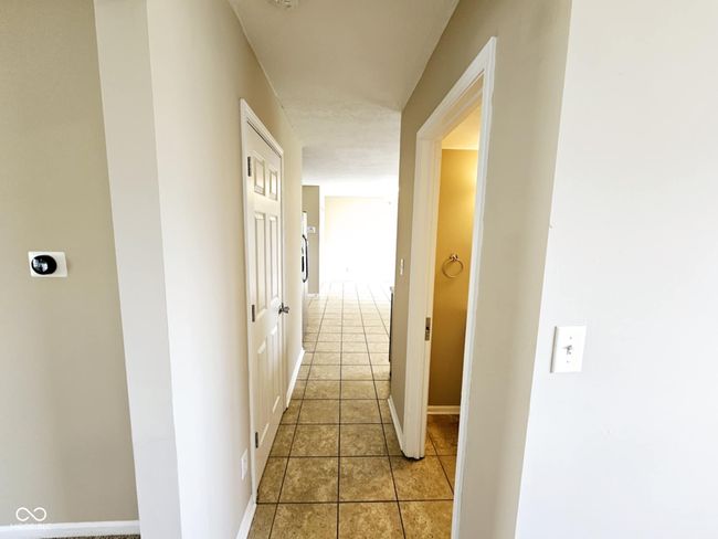 hall featuring light tile patterned flooring and baseboards | Image 16