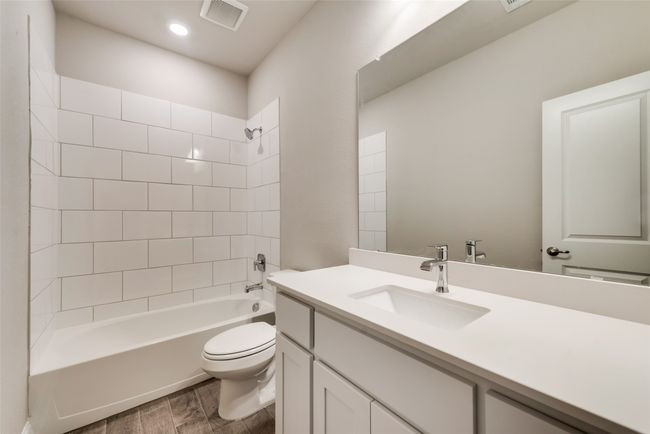 Full bathroom with tiled shower / bath combo, vanity, hardwood / wood-style floors, and toilet | Image 16