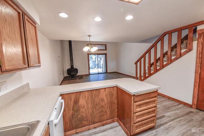 Kitchen with light wood-style flooring, a wood stove, a peninsula, and recessed lighting | Image 20