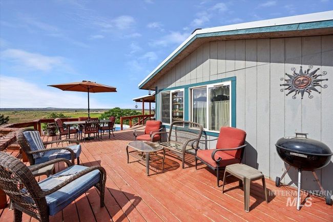 Wooden deck featuring area for grilling and outdoor dining space | Image 6