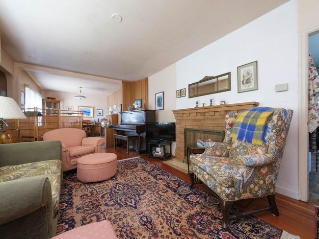 Living area featuring wood finished floors and a fireplace with flush hearth | Image 5