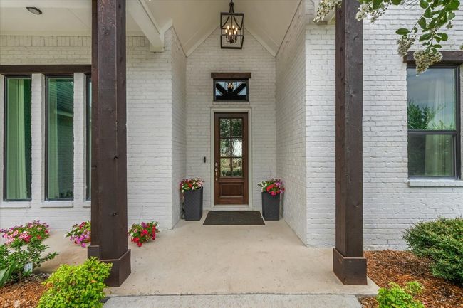 View of entry featuring Mahagony front door, vaulted ceiling & chandelier. | Image 33
