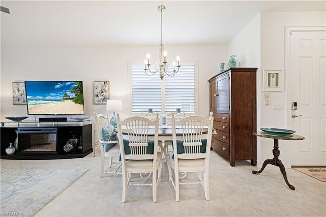 Dining room with a chandelier and light tile patterned flooring | Image 15