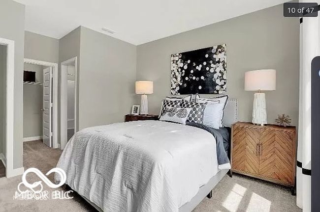 Bedroom on main level with carpet, carpeted bedroom with baseboards, spacious closet and an ensuite bathroom | Image 11