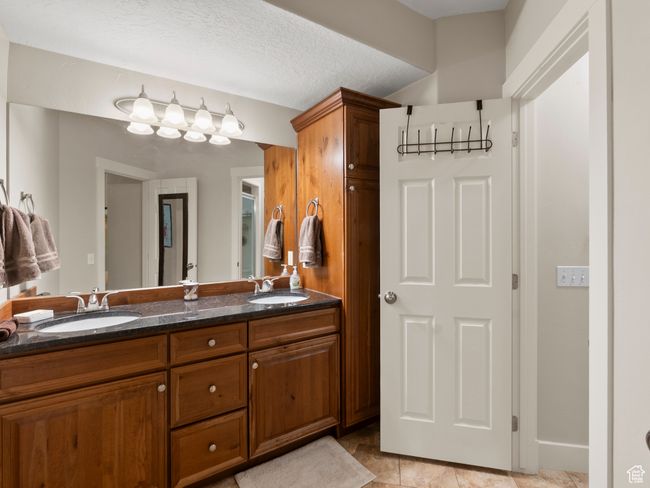 Full bath with double vanity and a textured ceiling | Image 27