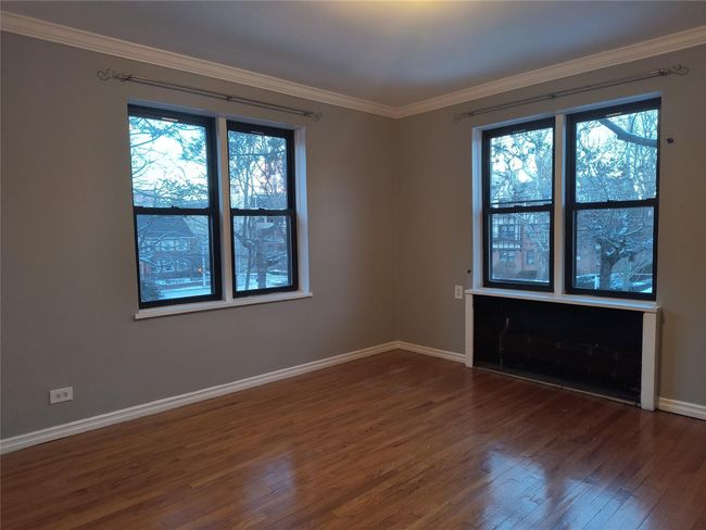 Empty room with crown molding, dark wood-style floors, and baseboards | Image 38