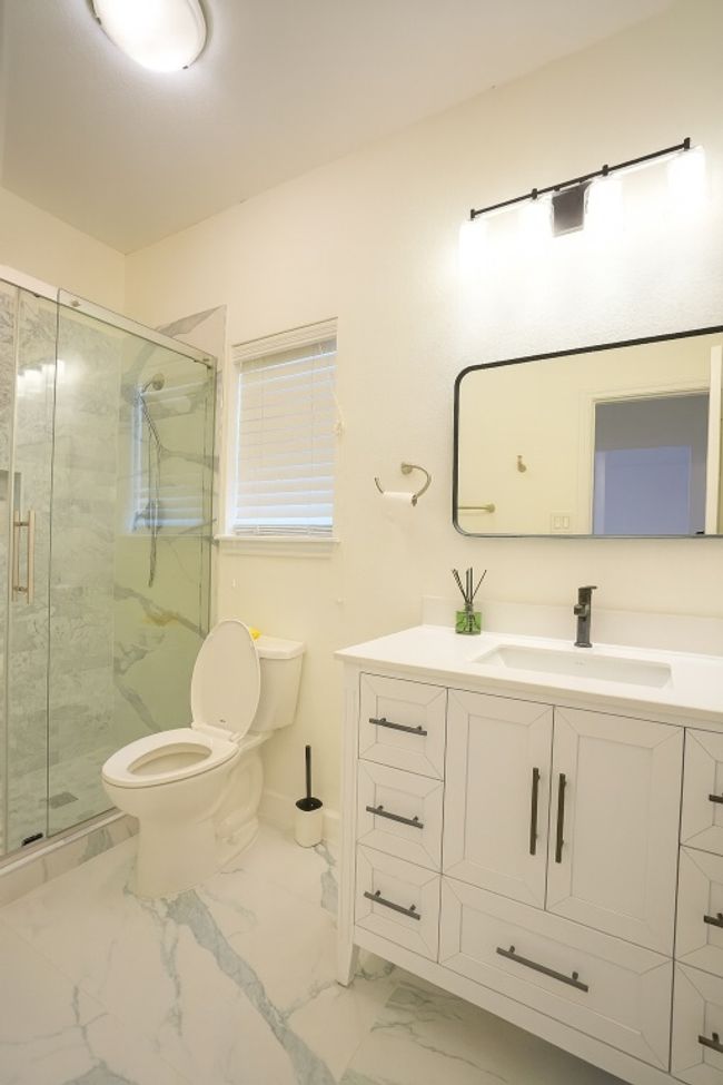 First floor Guest full bathroom with light marble finish flooring, vanity, and a marble finish shower | Image 17