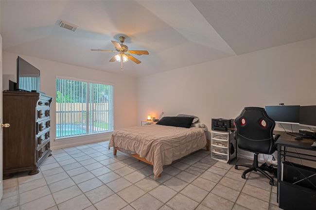 Spacious downstairs primary bathroom features serene views of the pool, offering a relaxing retreat just steps from the main suite. | Image 15