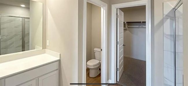 Full bathroom with vanity, toilet, a stall shower, and a walk in closet | Image 14