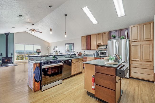 Beautifully charming and spacious Kitchen features vaulted ceilings, bamboo flooring, free standing island and stainless steel appliances. | Image 29