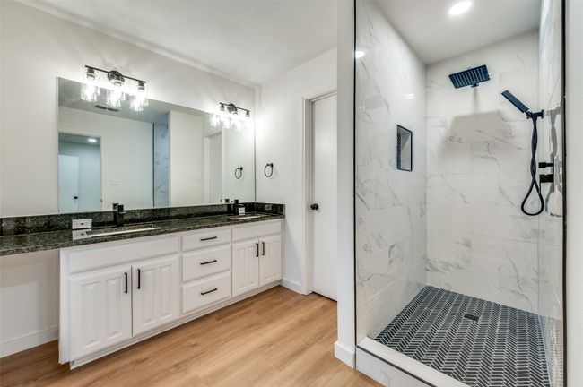Bathroom featuring a sink, a marble finish shower, double vanity, and wood finished floors | Image 24