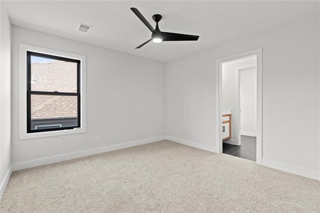 Unfurnished bedroom with dark carpet and a ceiling fan | Image 28