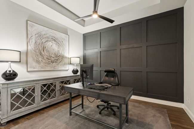 Office with a decorative wall, dark wood-style flooring, and ceiling fan | Image 6