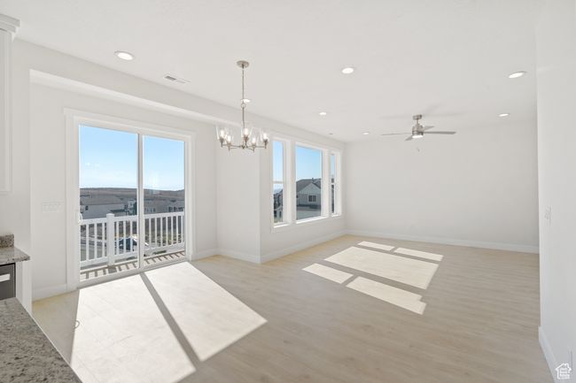 Unfurnished dining area featuring light wood-type flooring, recessed lighting, ceiling fan, and a chandelier | Image 10