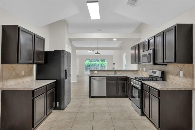 Kitchen. Refrigerator, dishwasher, garbage disposal, and five burner gas stove. | Image 19