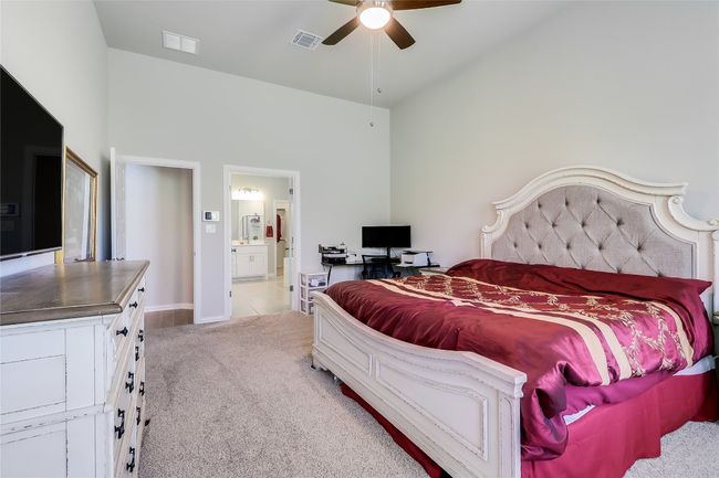 Bedroom with carpet floors, high vaulted ceiling, ensuite bath, baseboards, and a ceiling fan | Image 21