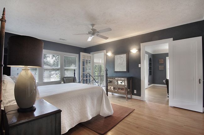 Bedroom with light wood-type flooring, baseboards, a textured ceiling, visible vents, and a ceiling fan | Image 10