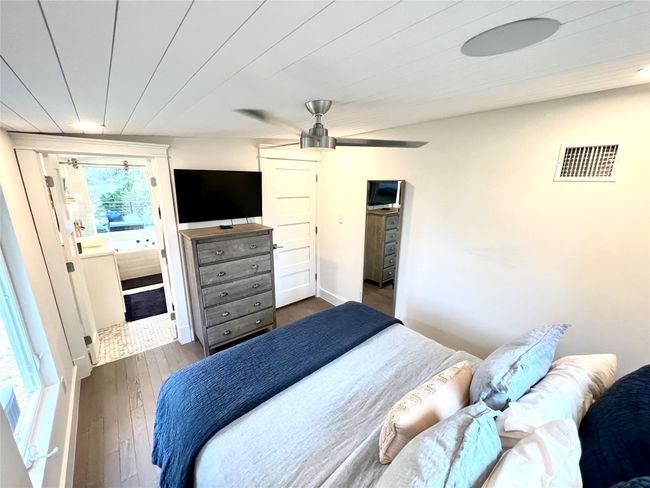 Bright and inviting primary bedroom featuring sleek finishes, ample natural light, and direct access to a chic en-suite bathroom. | Image 10