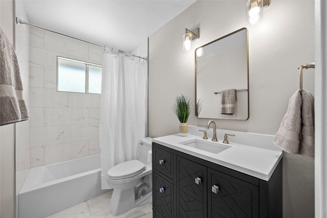 Updated in April 2025, the upstairs bathroom offers a shower / tub combo, lovely floors and gorgeous vanity | Image 23