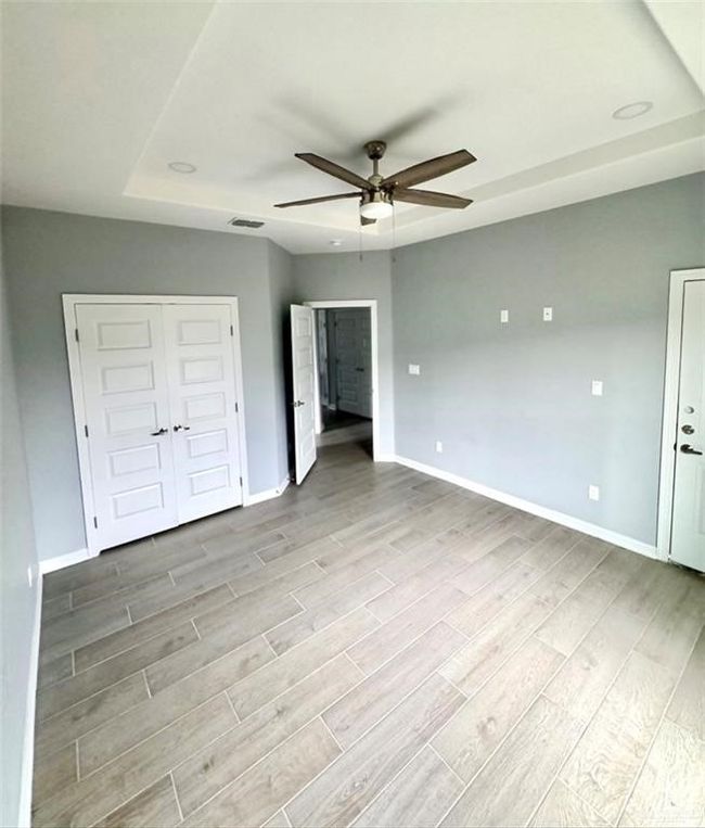 Unfurnished bedroom with baseboards, visible vents, and wood finish floors | Image 7