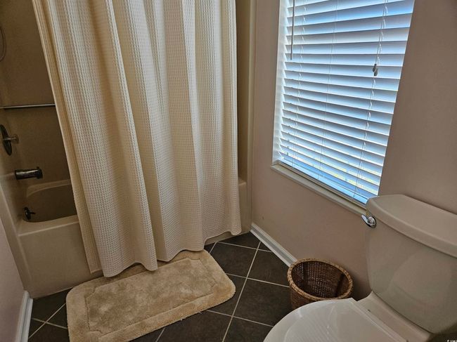 Bathroom featuring tile patterned floors and shower / bath combo | Image 17