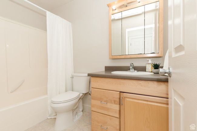 Full bathroom featuring vanity, tile patterned floors, and shower / bath combination with curtain | Image 16