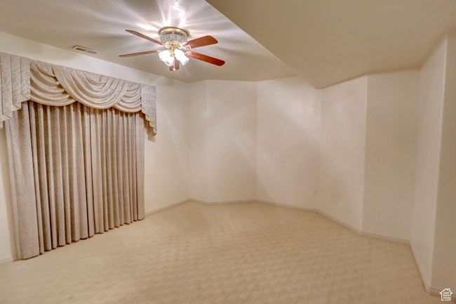 Carpeted spare room featuring visible vents, baseboards, and ceiling fan | Image 42