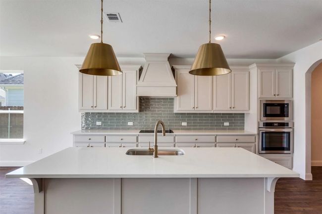 Kitchen with sink, stainless steel appliances, dark hardwood / wood-style flooring, pendant lighting, and custom exhaust hood | Image 8