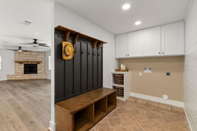 Effortlessly transition from outdoors to indoors with this stylish and functional laundry/mud room, featuring ample storage, convenient seating, and modern design. | Image 28