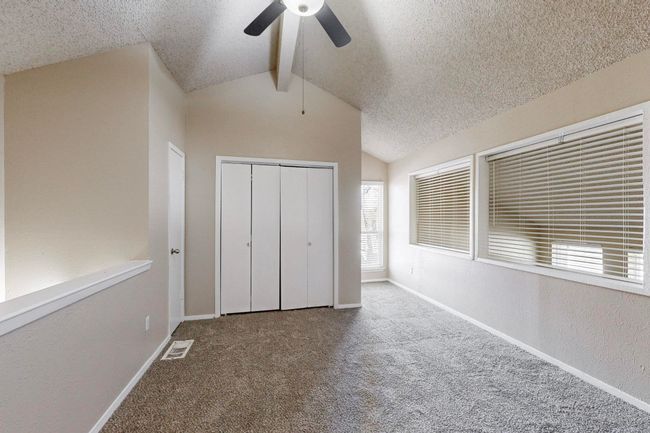 Unfurnished bedroom featuring visible vents, lofted ceiling, a textured ceiling, carpet floors, and baseboards | Image 28