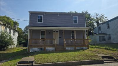 View of property with covered porch and a front lawn | Image 1