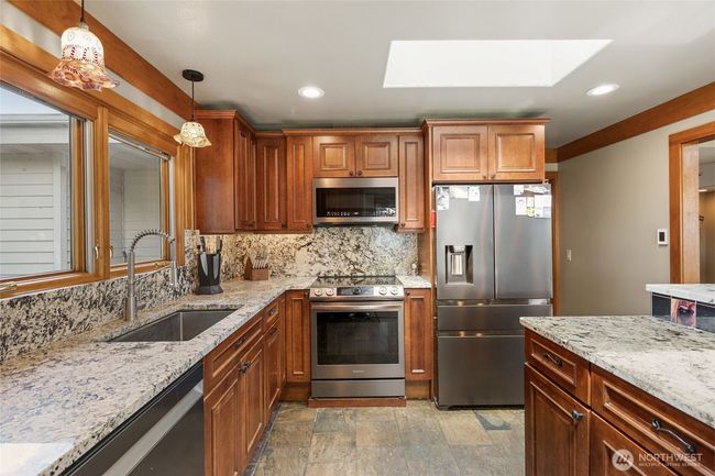 Lots of recessed lighting above and below the custom cabinets. Pull out garbage bin for easy clean up. | Image 11
