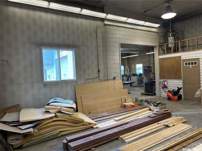 Miscellaneous room with concrete block wall, a towering ceiling, and concrete flooring | Image 35