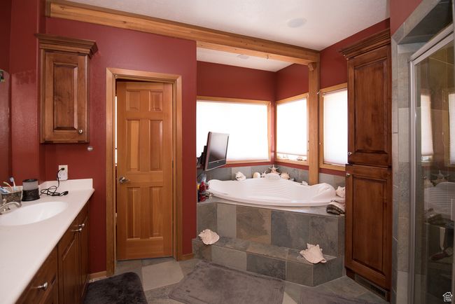 Bathroom featuring a bath, vanity, and a stall shower | Image 61