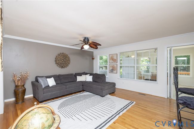 Living area featuring ornamental molding, a ceiling fan, and light wood-style floors | Image 9