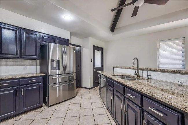 Kitchen featuring tasteful backsplash, appliances with stainless steel finishes, light stone counters, and a sink | Image 14