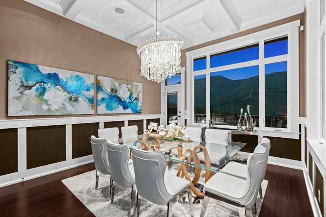 Dining space featuring coffered ceiling, a notable chandelier, wood finished floors, and a mountain view | Image 8