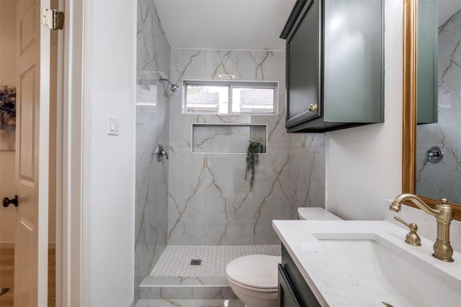 Full bath with toilet, a marble finish shower, and vanity | Image 21