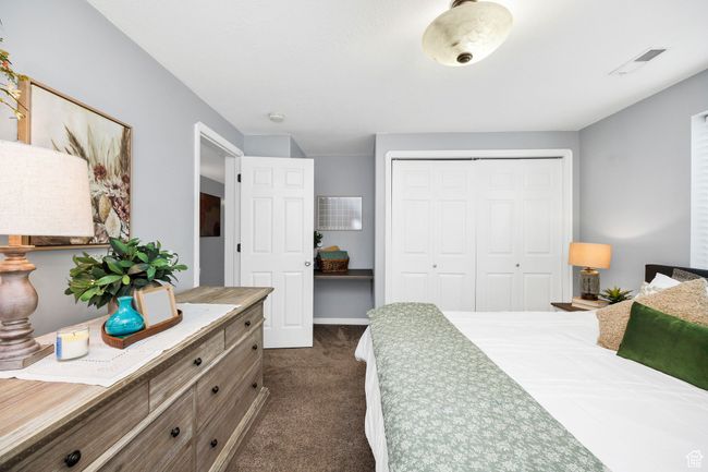 Bedroom featuring dark colored carpet, visible vents, and a closet | Image 33