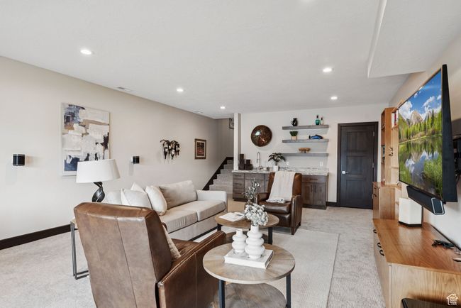 Living room with light colored carpet, stairway, bar, and recessed lighting | Image 48