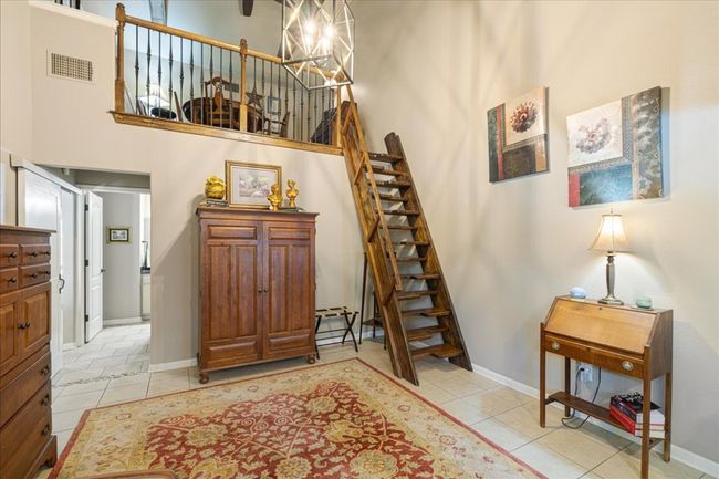 Stairway featuring baseboards, a chandelier, tile patterned flooring, a high ceiling, and visible vents | Image 28