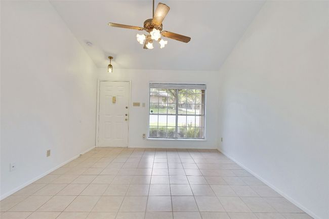 Spare room featuring vaulted ceiling, a ceiling fan, and light tile patterned floors | Image 16