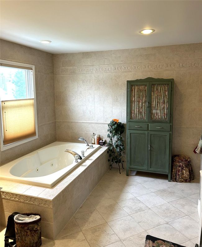 Full bathroom featuring a jetted tub and tile patterned floors | Image 28