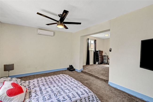 Bedroom featuring an AC wall unit, carpet, and a ceiling fan | Image 29