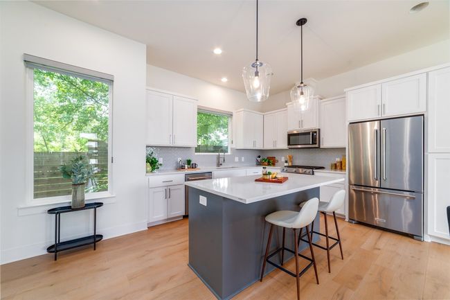 Kitchen with appliances with stainless steel finishes, light wood-style floors, light countertops, white cabinetry, and recessed lighting | Image 8