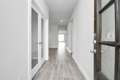 The majestic entryway allures with its high ceilings, embellished with sophisticated wood-look tile flooring and sleek oversized baseboards. Sample photo of completed home with similar floor plan. Actual colors and selections may vary. | Image 2