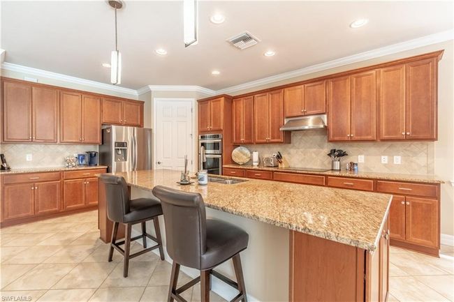 Tiled dining area with an inviting chandelier and crown molding | Image 13