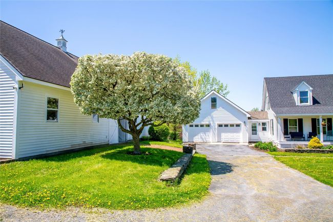 View of front of property featuring asphalt driveway, a front yard, covered porch, and roof with shingles | Image 40