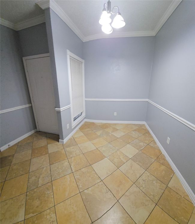 Unfurnished room with a chandelier, crown molding, and light tile patterned flooring | Image 9
