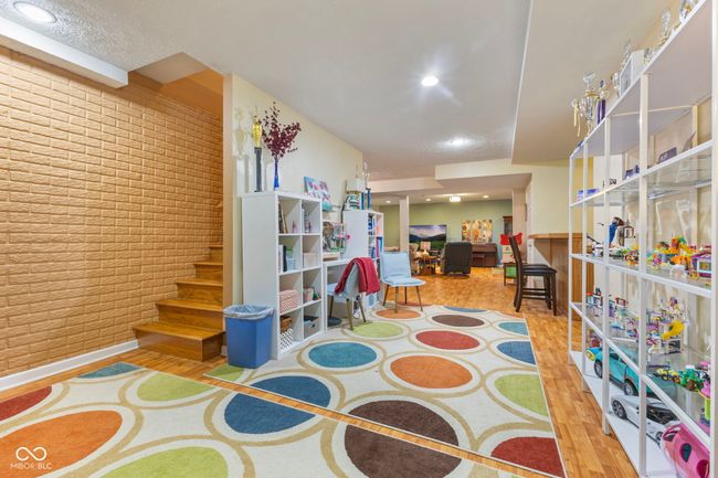 interior space featuring brick wall, recessed lighting, wood finished floors, and stairway | Image 25
